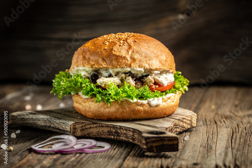 Tasty fired chicken with salad and mayonnaise sauce served on rustic wooden background. fast food and junk food concept