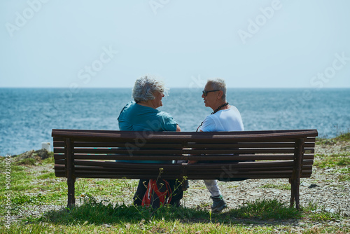 Dos Mujeres Seniors hablan amistosamente mirando el mar photo