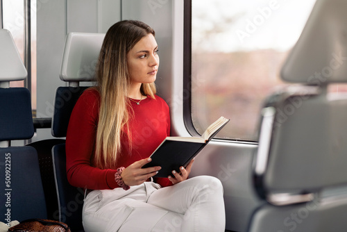 Girl Reading Book in Train