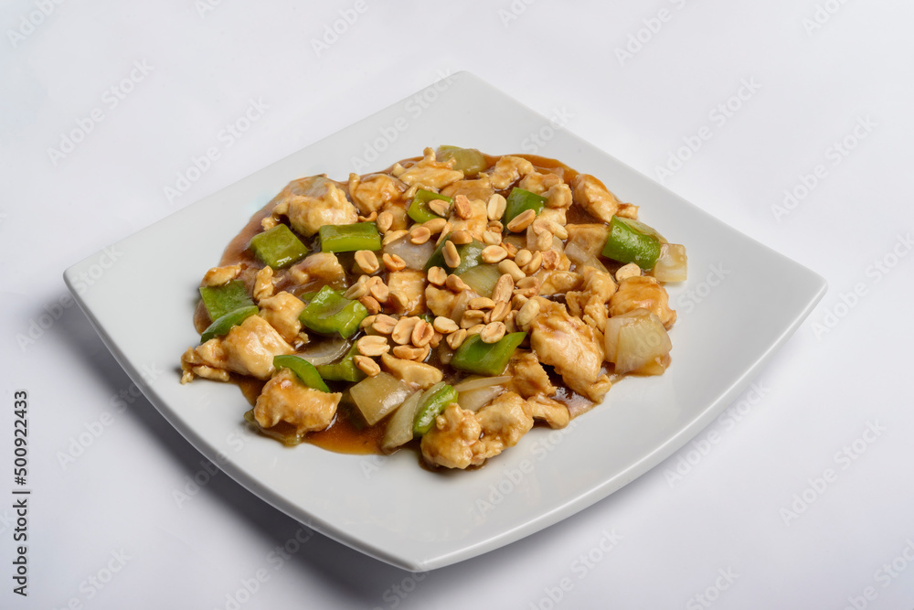 Chess chicken with green peppers, onions and peanuts in white plate isolated. Chinese traditional food. Chess chicken with green peppers, onions and peanuts in white plate isolated. Chinese traditional food.