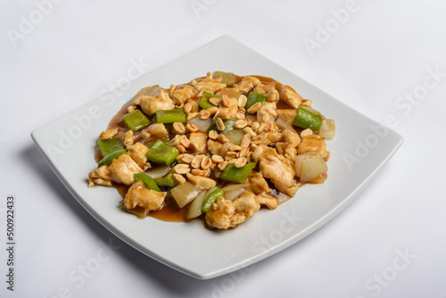 Chess chicken with green peppers, onions and peanuts in white plate isolated. Chinese traditional food.