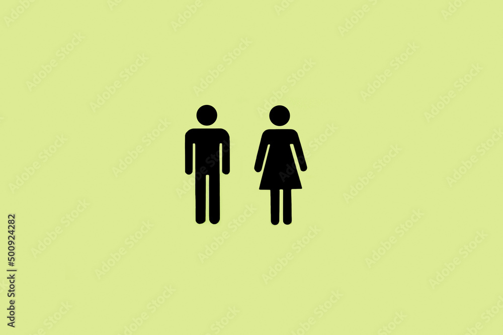 Iconos de baño masculinos y femeninos sobre un fondo verde liso y aislado. Vista de frente. Copy space - obrazy, fototapety, plakaty 