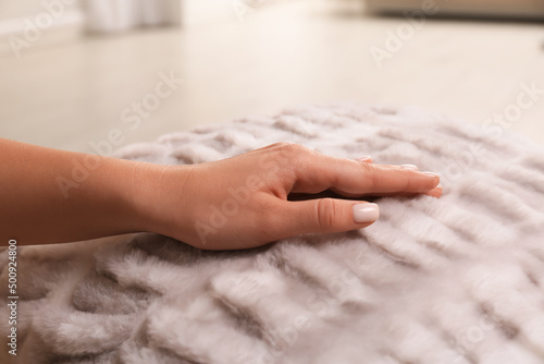 Woman touching soft fabric indoors, closeup view