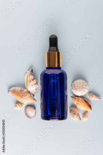 Face serum close-up on the trendy blue background. Collagen, hyaluronic acid for skin care. modern science in cosmetic for anti-aging procedures