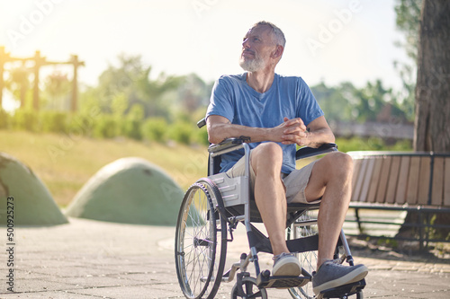 A man in shorts sitting in a wheel chai