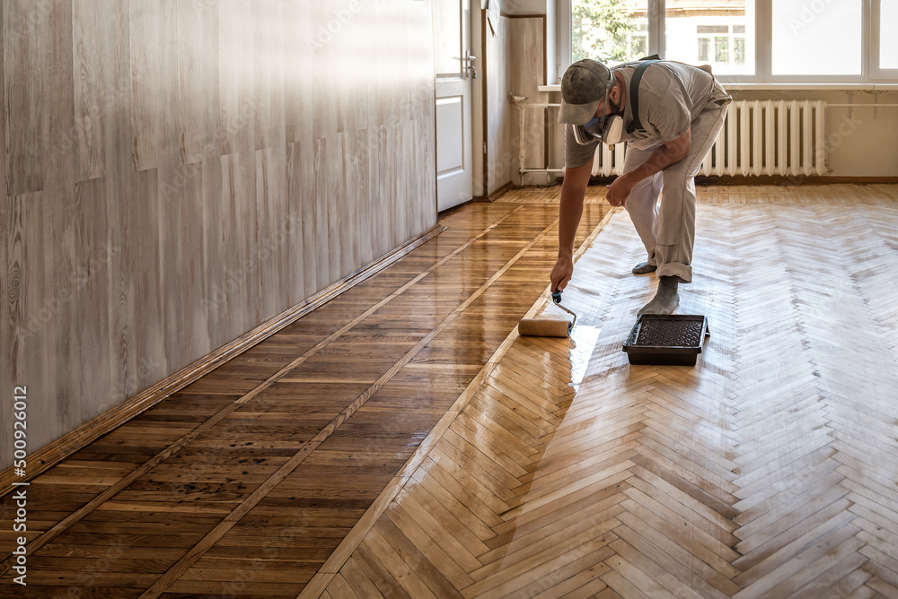 worker lacquering parquet floors - obrazy, fototapety, plakaty 