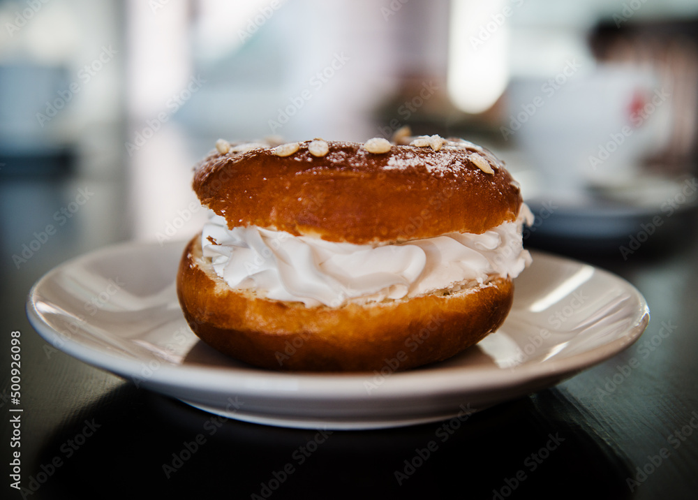 Glazed donut with whipped cream and powdered sugar Glazed donut with whipped cream and powdered sugar