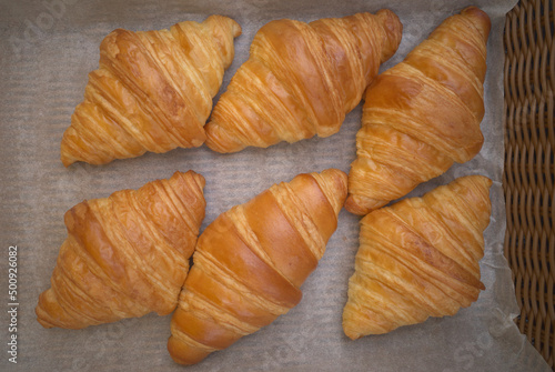 Classic French croissant or butter croisant in wooden basket which is viennoiserie pastry of Austrian origin
