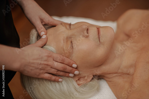 A senior woman having a face massage in a beauty salon