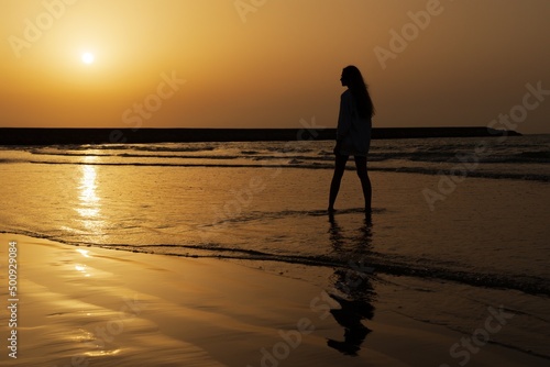 Silhouette of a woman against the sunset over the sea