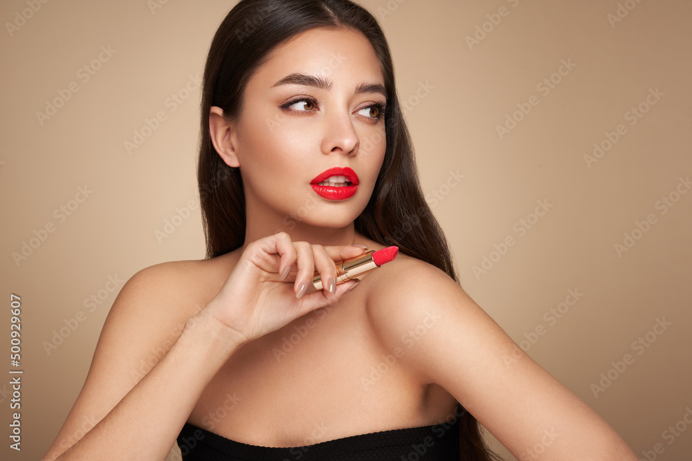 A beautiful young woman applying lipstick. Model with healthy skin, close up portrait. Cosmetology, beauty and spa A beautiful young woman applying lipstick. Model with healthy skin, close up portrait. Cosmetology, beauty and spa