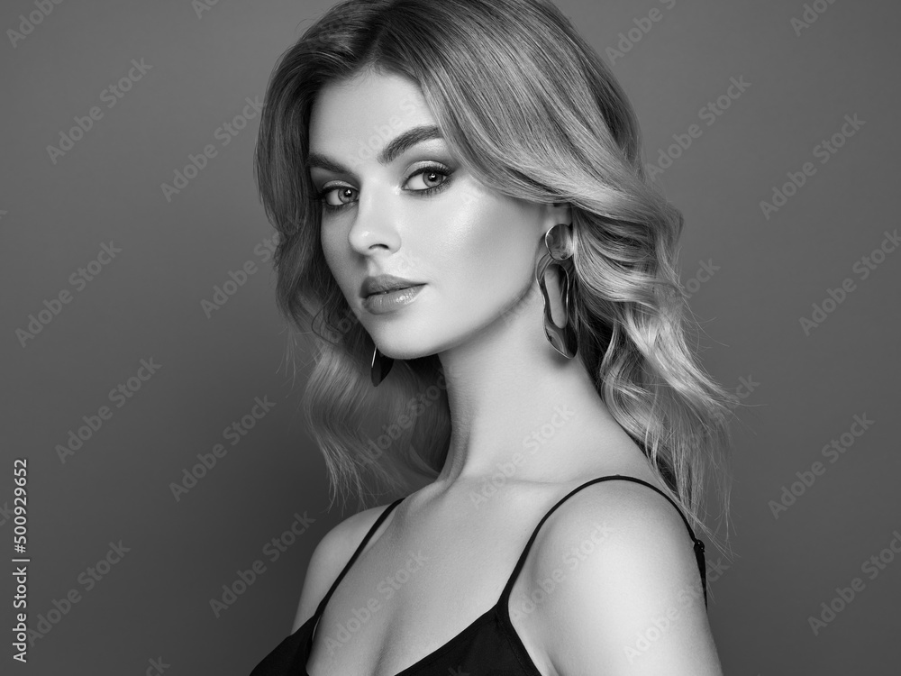 Fototapeta premium A beautiful young woman with shiny wavy blonde hair. Model with healthy skin, close up portrait. Cosmetology, beauty and spa