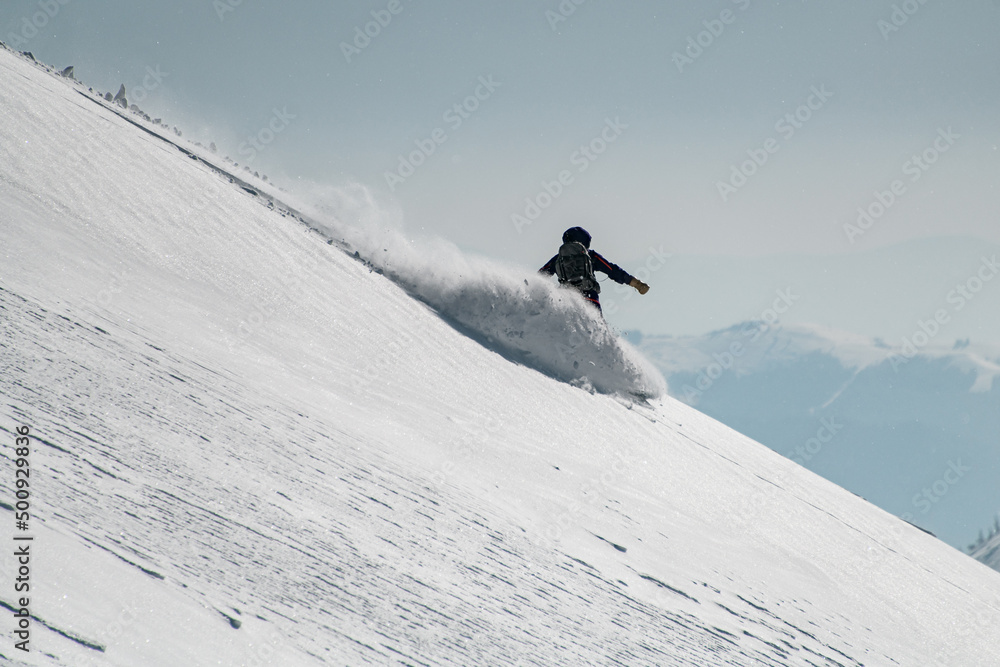 amazing view on male skier slides down the snow-covered slope. Freeride skiing concept