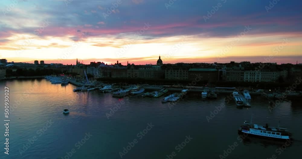 Aerial Beautiful Shot Of Buildings Against A Dramatic Sky, Drone Flying Backwards Over Sea - Stockholm, Sweden Aerial Beautiful Shot Of Buildings Against A Dramatic Sky, Drone Flying Backwards Over Sea - Stockholm, Sweden