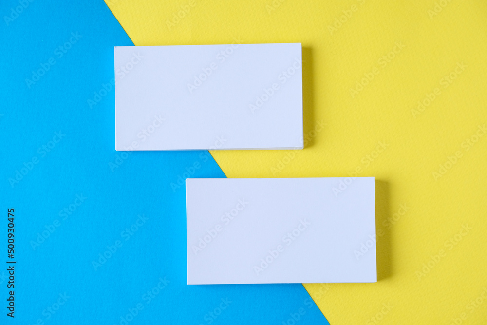 Two business cards on a colour background
