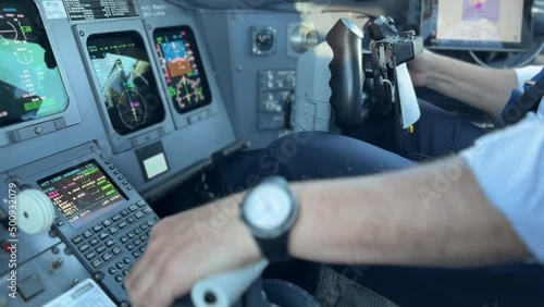 Cockpit view of a jet while copilot is landing with unfocused background photo