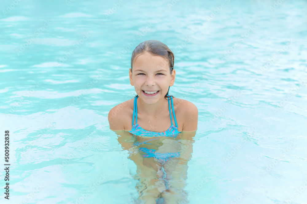 Happy child girl  in swimming pool. Summer vacation concept.
