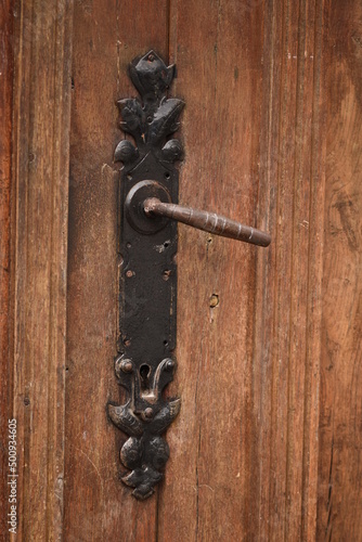  Ancient rusty door handle on brown old wooden door