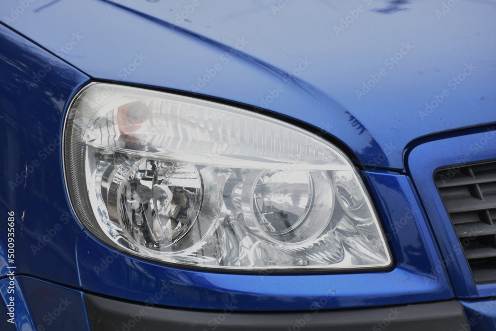 shiny headlight on a blue  car