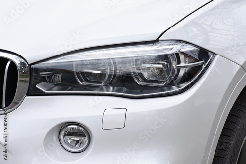shiny headlight on a  gray car © Laurenx