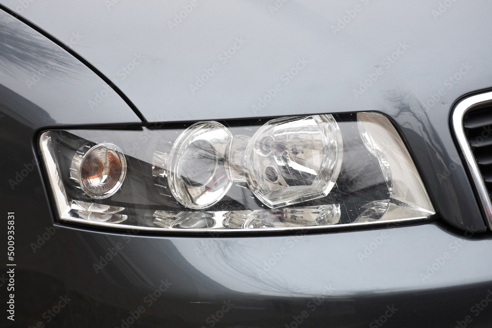 shiny headlight on a  gray car