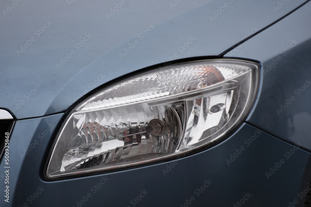 shiny headlights on a gray  blue car