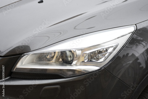 shiny headlights on a gray car © Laurenx