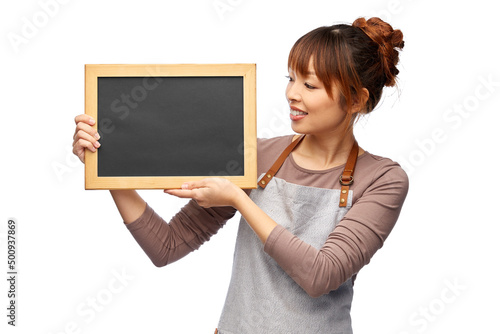 cooking, culinary and people concept - happy smiling female chef or waitress in apron with chalkboard over white background