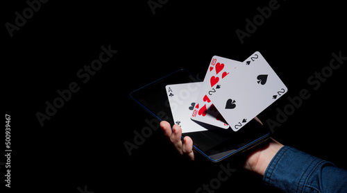 human hand holding a phone and playing cards emerging from there
