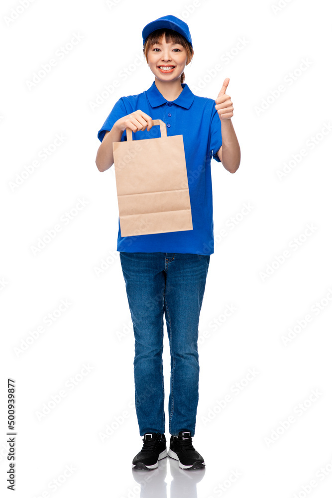service and job concept - happy smiling delivery woman in blue uniform with takeaway food in paper bag showing thumbs up over white background service and job concept - happy smiling delivery woman in blue uniform with takeaway food in paper bag showing thumbs up over white background