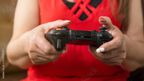 hands of mature woman with video game controller