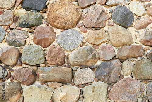 Fragment of an old stone wall. Ancient rock background
