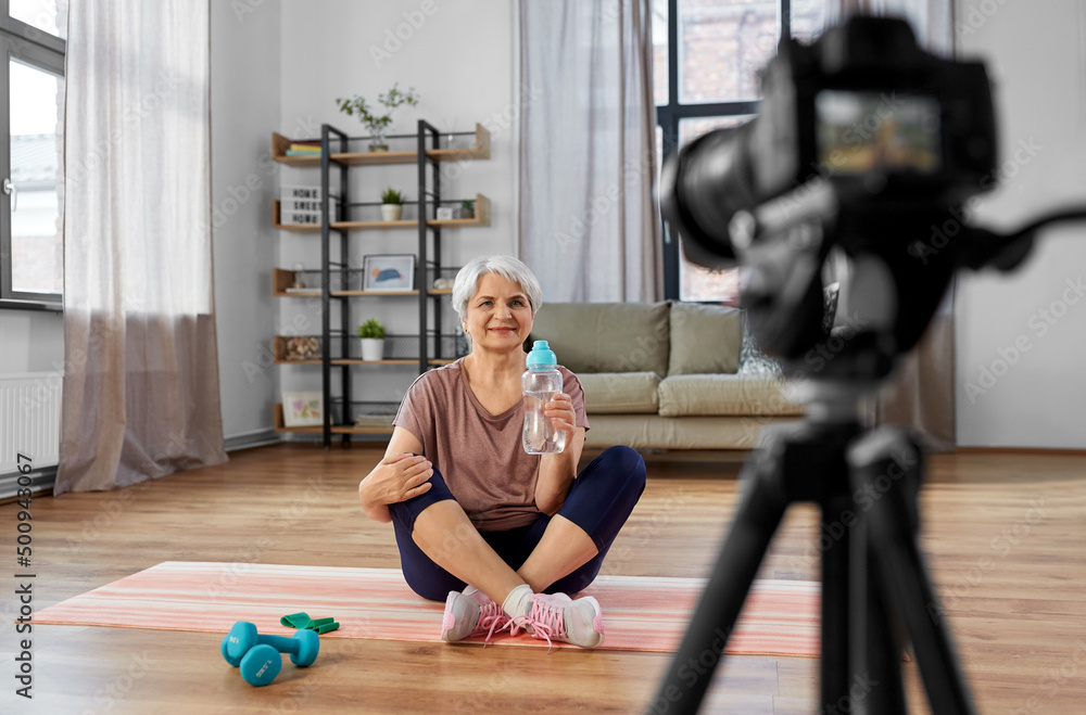 fitness, sport and video blogging concept - happy senior woman or blogger with camera streaming online class at home fitness, sport and video blogging concept - happy senior woman or blogger with camera streaming online class at home