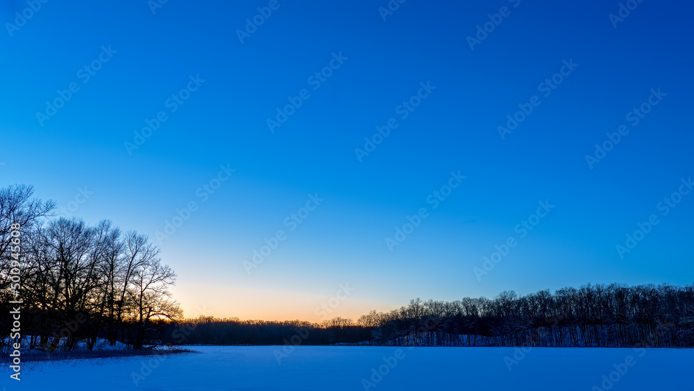 Fototapeta premium Winter sunset over Haven Hill Lake, Haven Hill Natural Area, Highland Recreation Area, Oakland County, Michigan