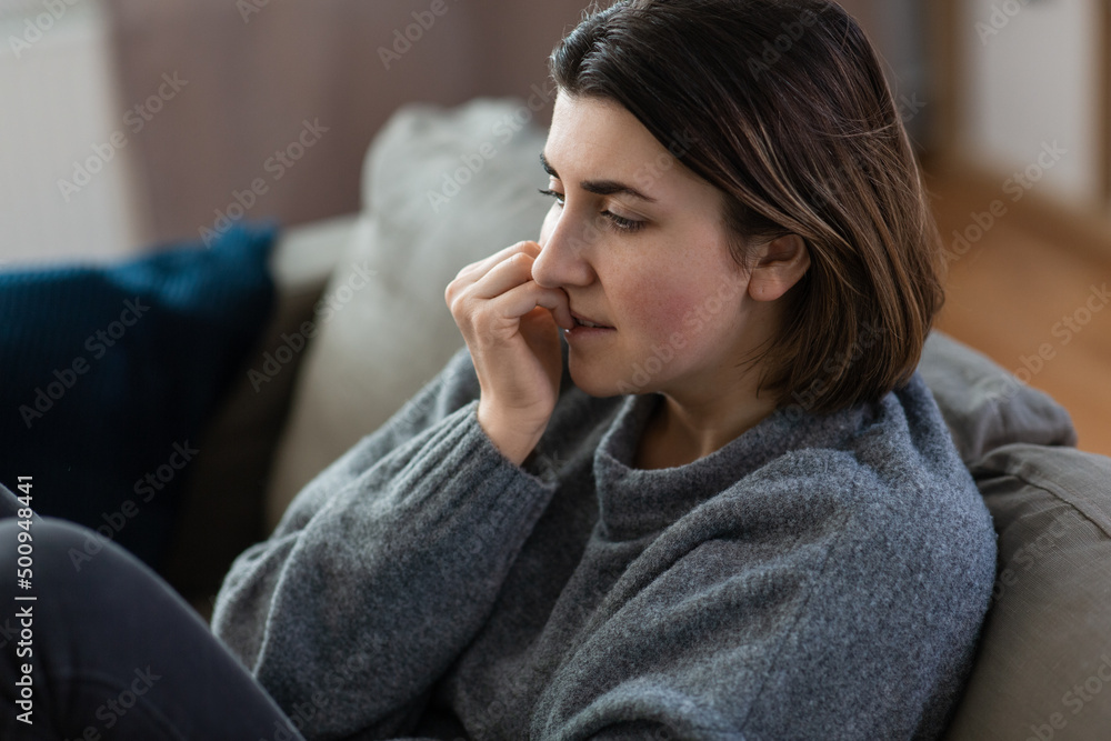 mental health, psychological problem and depression concept - stressed woman sitting on sofa at home mental health, psychological problem and depression concept - stressed woman sitting on sofa at home