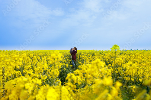 Mother alone standing with her baby in a field-Ukrainian flag concept