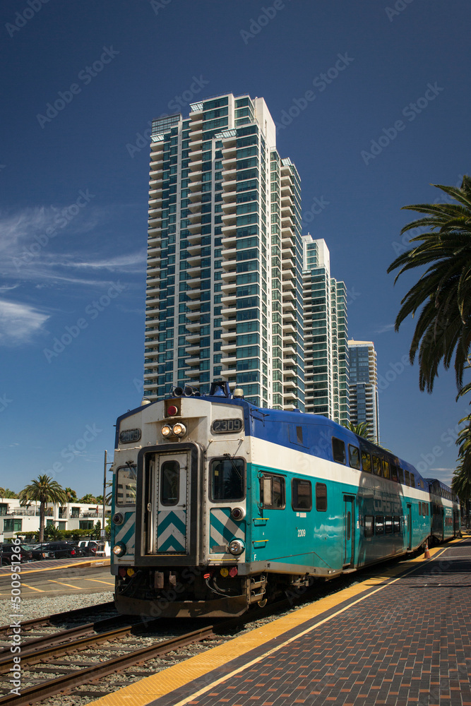 Obraz premium Train running on Santa Fe Depot in front of some high towers of apartments, San Diego