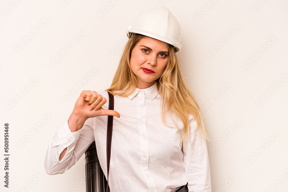 Young architect woman with helmet and holding blueprints isolated on white background showing a dislike gesture, thumbs down. Disagreement concept. Young architect woman with helmet and holding blueprints isolated on white background showing a dislike gesture, thumbs down. Disagreement concept.