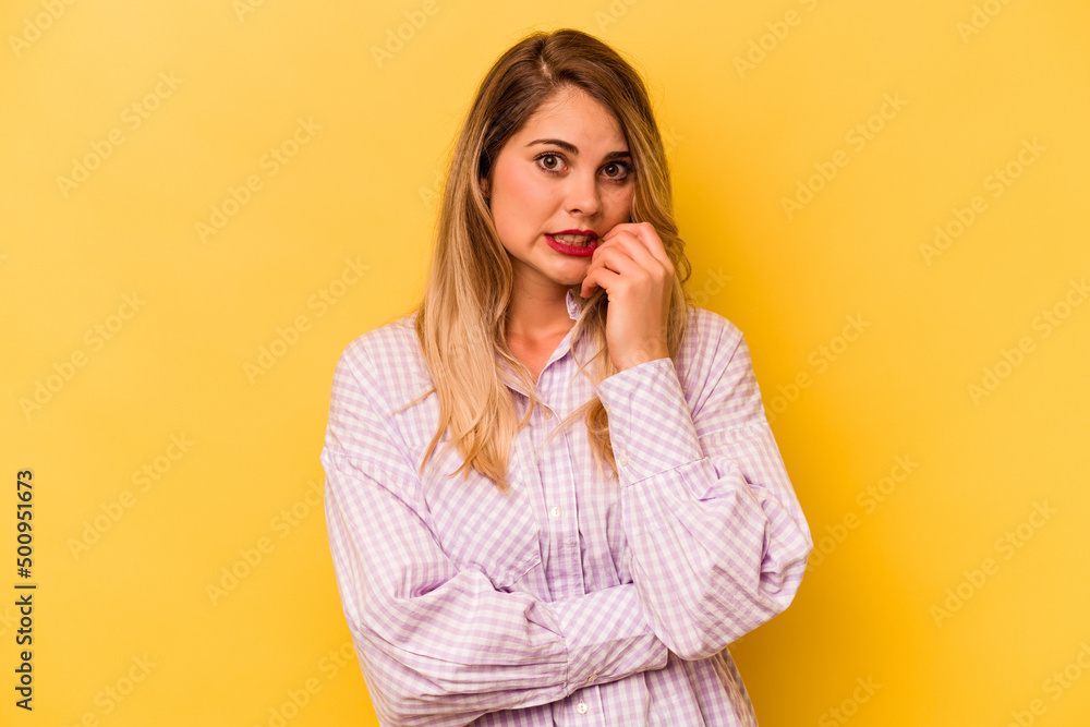 Young caucasian woman isolated on yellow background biting fingernails, nervous and very anxious. Young caucasian woman isolated on yellow background biting fingernails, nervous and very anxious.