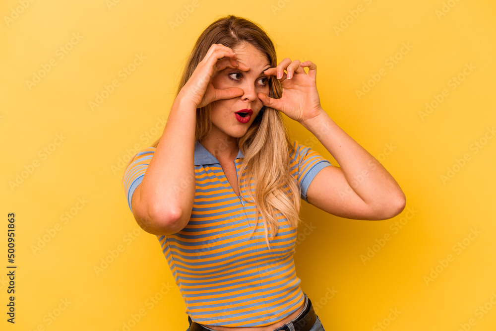 Young caucasian woman isolated on yellow background keeping eyes opened to find a success opportunity.