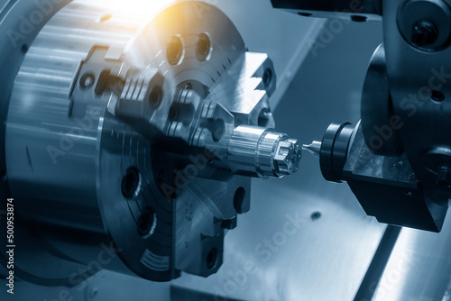 The  CNC turn-mill machine chamfer cutting the metal shape parts. photo