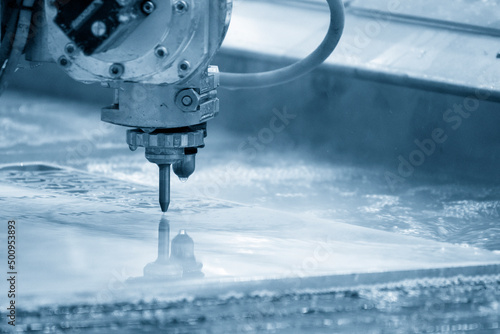 The multi-axis waterjet cutting machine cutting the aluminum plate. photo