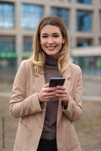 Portrait of young business woman using phone outdoors