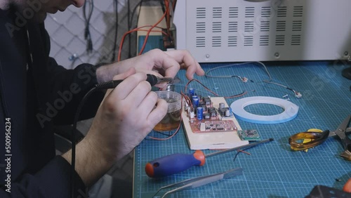 Soldering is done on the microchips in the factory with a soldering machine. electronic working hands.