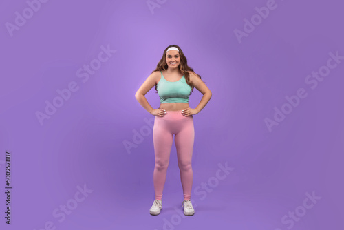 Cheerful confident millennial european plus size woman athlete in sportswear look at camera