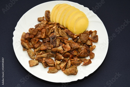 mushrooms fried with goldene apples sliced on a white plate