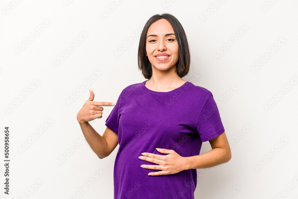 Young hispanic pregnant woman isolated on white background person pointing by hand to a shirt copy space, proud and confident Young hispanic pregnant woman isolated on white background person pointing by hand to a shirt copy space, proud and confident