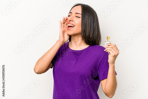 Young hispanic pregnant woman holding pacifier isolated on white background shouting and holding palm near opened mouth.