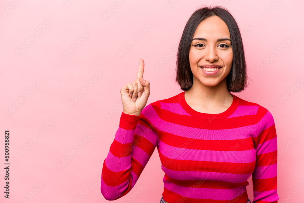 Young hispanic woman isolated on pink background showing number one with finger. Young hispanic woman isolated on pink background showing number one with finger.