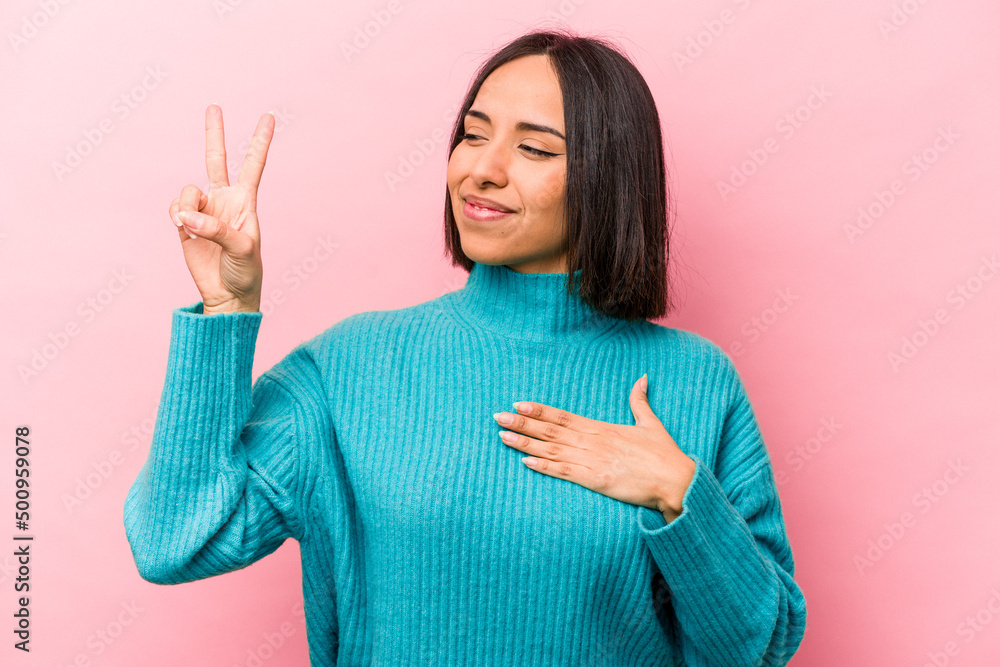 Young hispanic woman isolated on pink background taking an oath, putting hand on chest. Young hispanic woman isolated on pink background taking an oath, putting hand on chest.